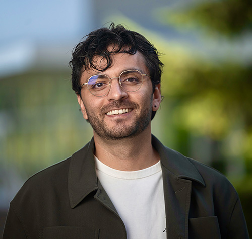 brown haired man with glasses smiling